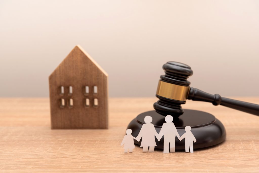 paper family cutout with gavel and wooden house model on wooden desk,Family law and heritage concept